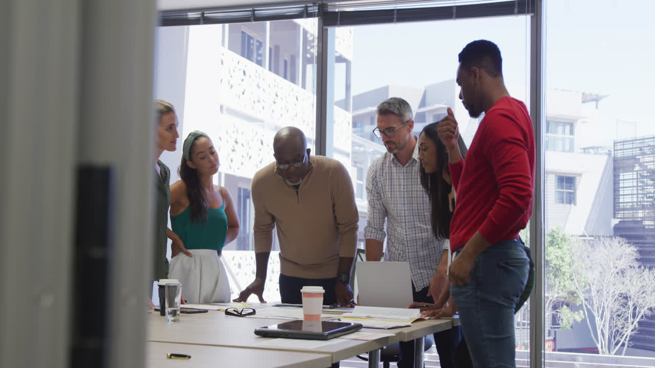 Diverse male and female business colleagues talking at meeting