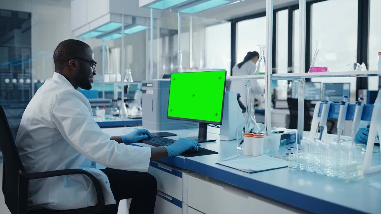 Modern Medical Research Laboratory: Scientist working on Computer Showing Green Chroma Key Screen. Scientific Lab, Medicine Development Facility with Advanced Equipment, Biotechnology. Zoom Out Shot