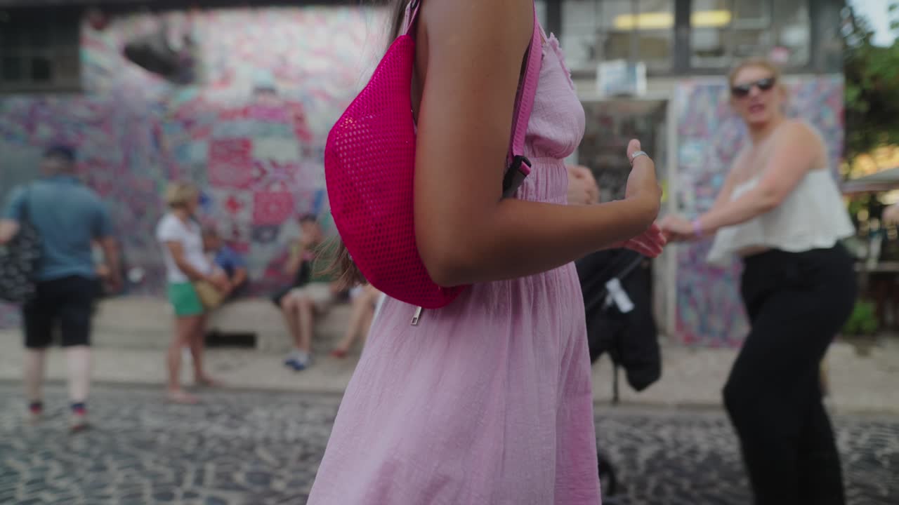 A woman with a pink bag on a street