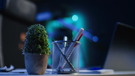 laptop, headphones and mini house plants on table in apartment room