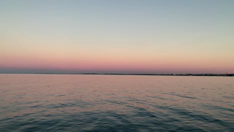 Hermosa-Vista-De-La-Bahía-Del-Mar-Báltico-Al-Atardecer,-Cielos-Despejados-En-El-Horizonte,-Sombras-Naranjas-En-La-Distancia-Y-Un-Mar-Tranquilo