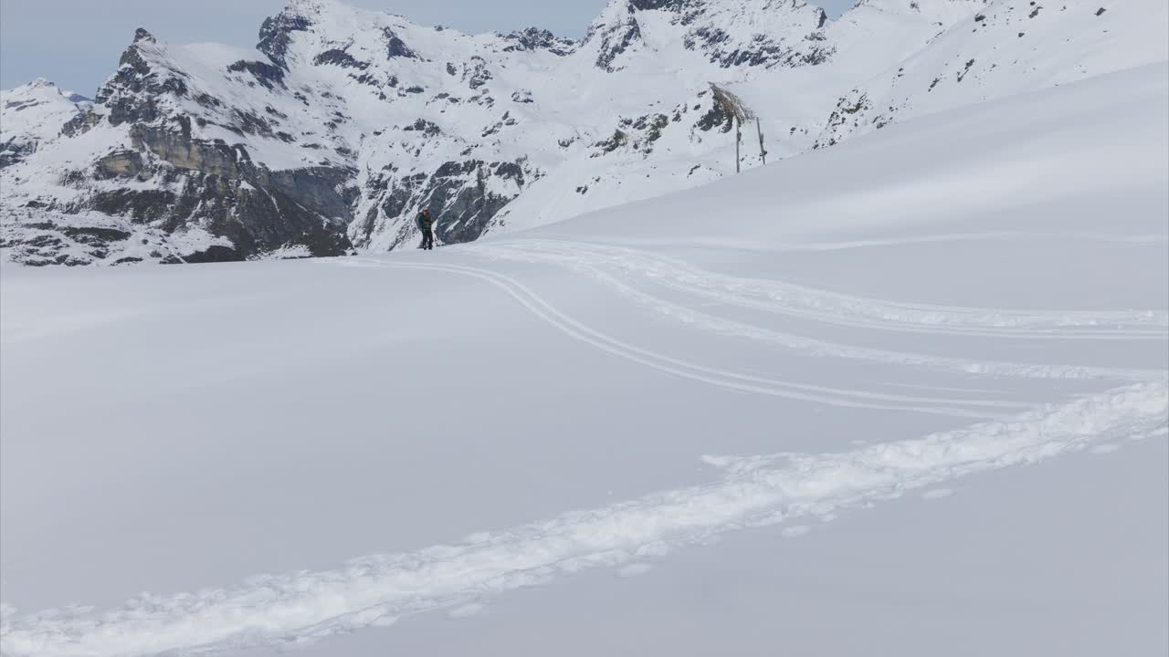 Two snowshoers across vast snowy mountain landscape, Alps scenery, winter sports, copy space