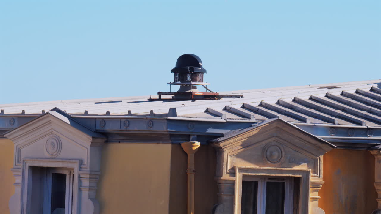 Close up of the facade and rooftop of a yellow building in Nice, France