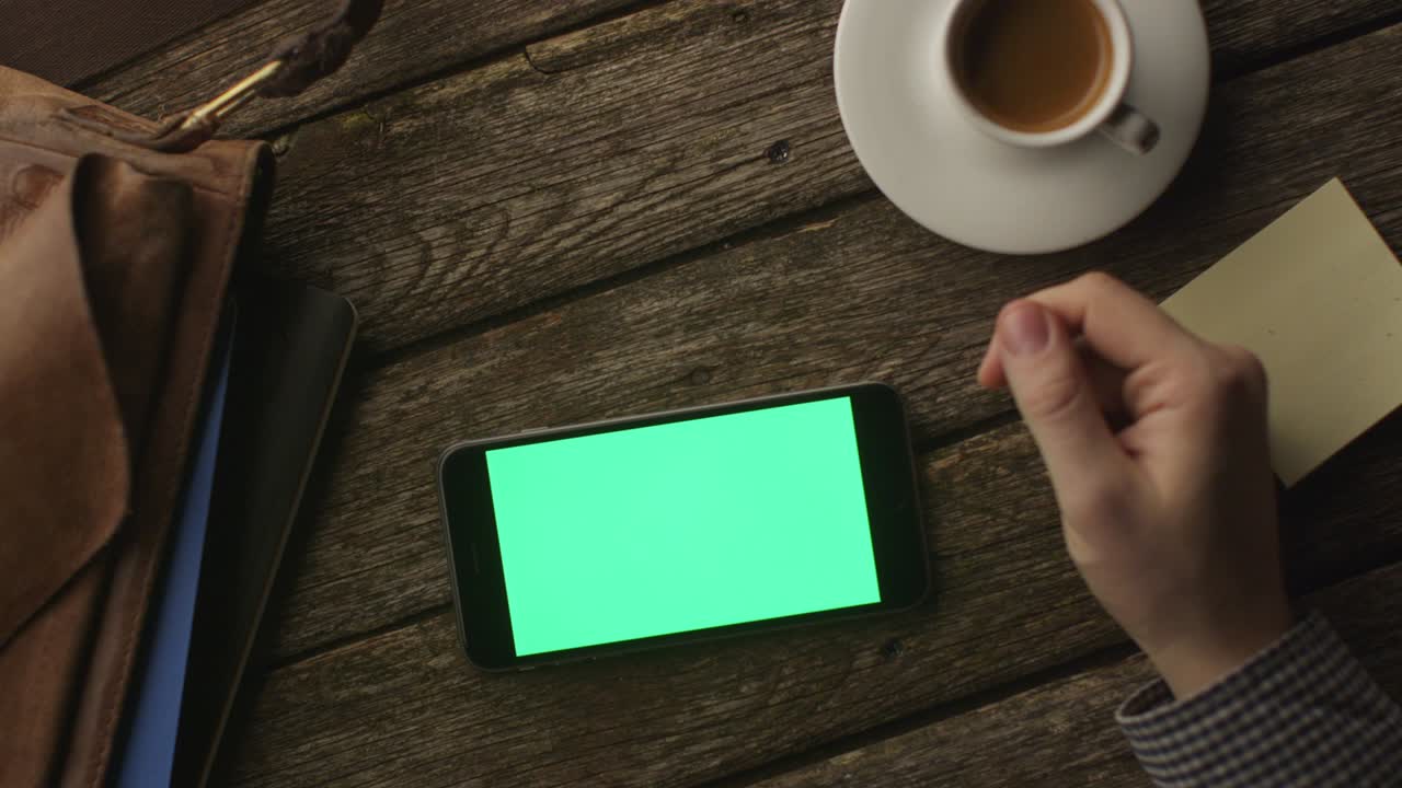 el uso del teléfono en modo paisaje en la mesa de madera en el hogar. vista superior. estilo de vida causal