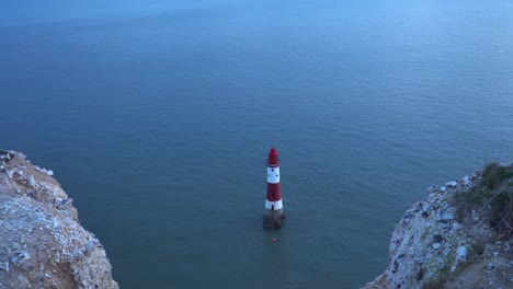 red and white lighthouse by chalk cliff