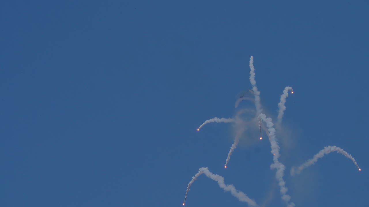 Airplane releasing flares in the sky