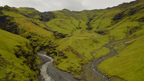 río que fluye en el valle volcánico verde en las tierras altas de islandia