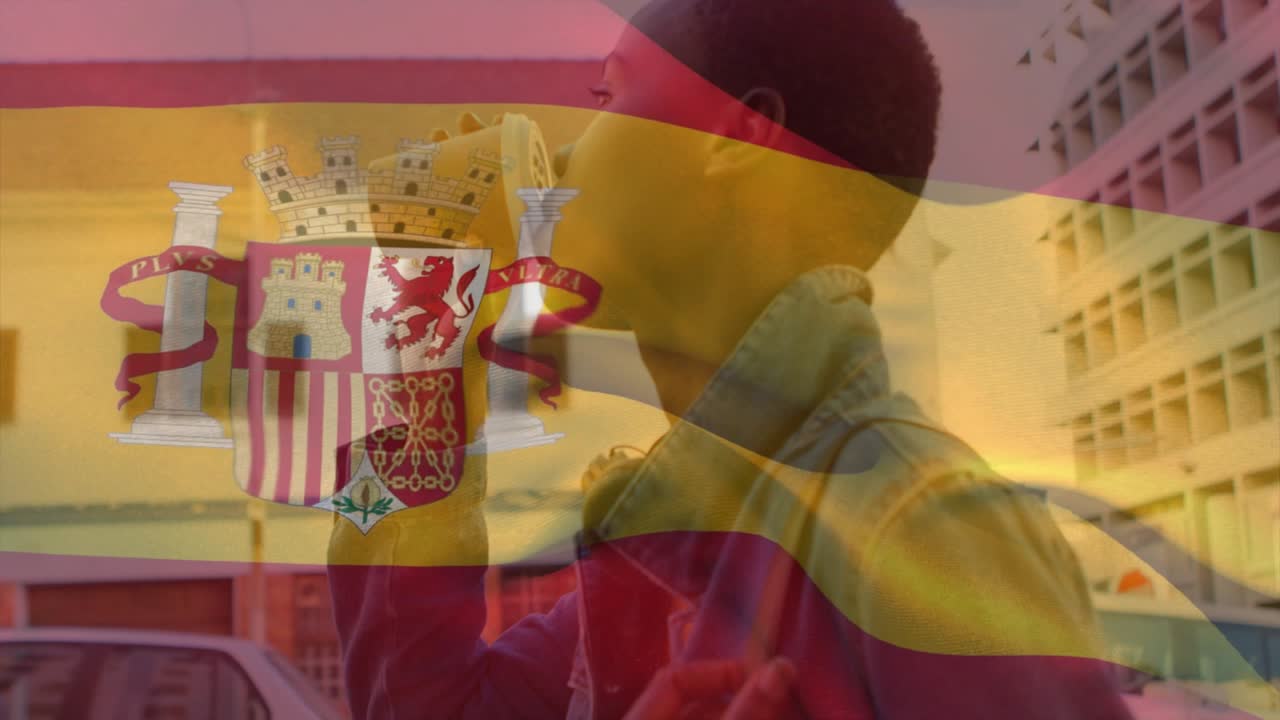 Bardak tutan bir kadın, seyahat için sokağı tararken bardağını kaldırıp yudumluyor, İspanyol bayrağı kaplaması.
