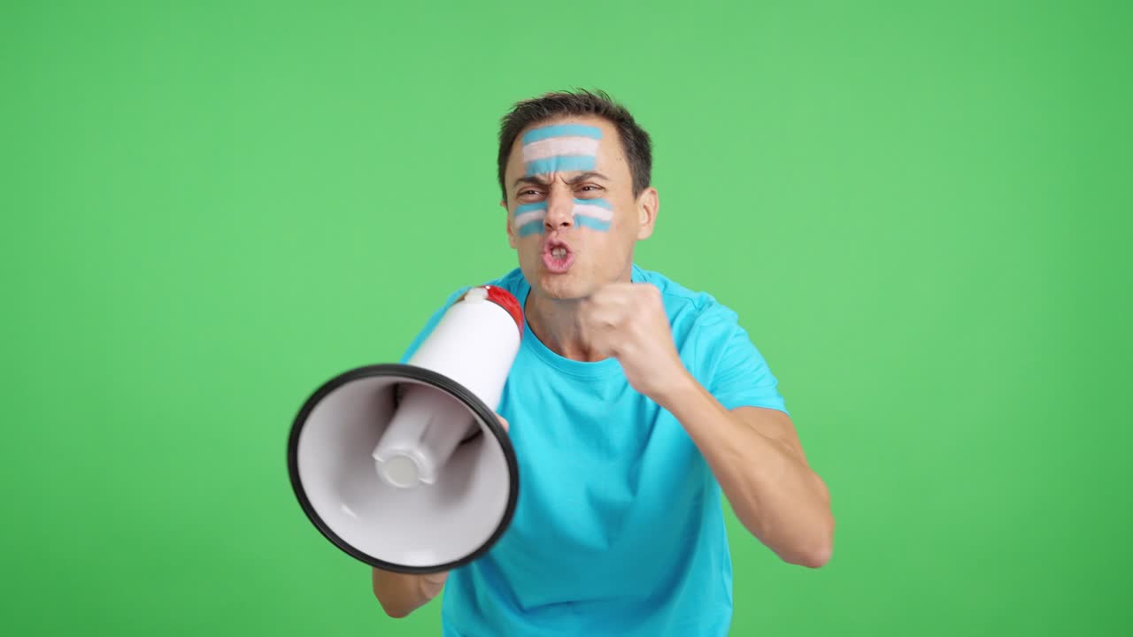 Excited man with argentine flag on face using a megaphone