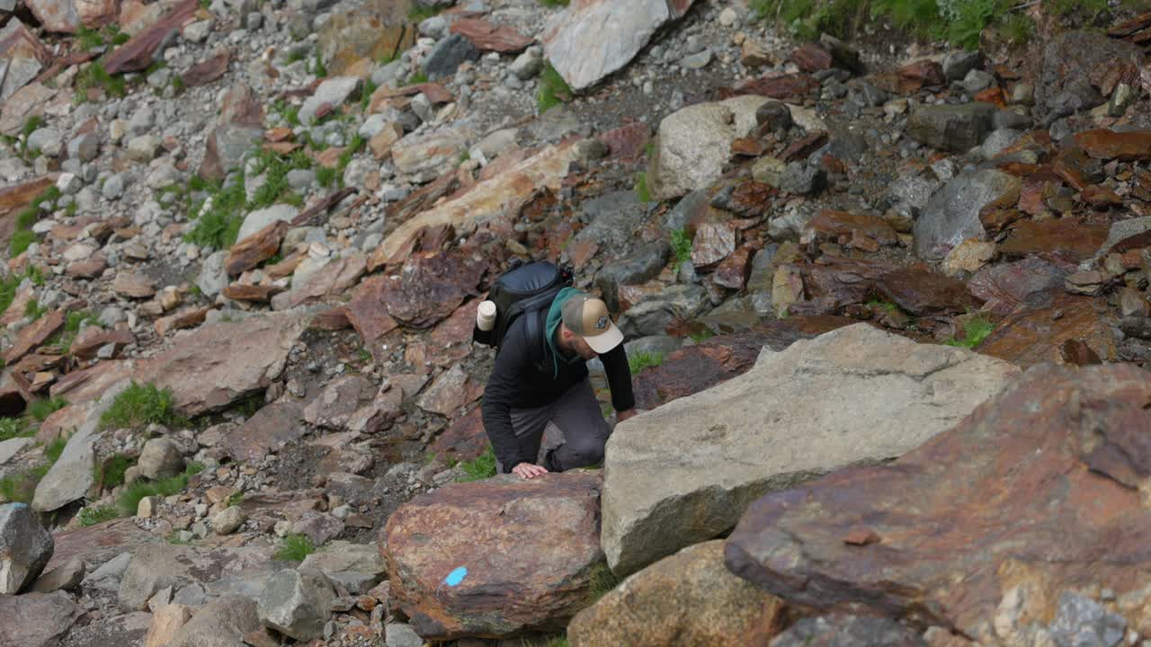 Traveler Climbing On Boulders In Valmalenco, Italy