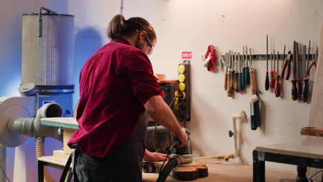 Carpenter-collaborating-with-apprentice,-using-orbital-sander