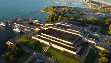 drone footage of scenic aerial view of linnahall opera house theather in tallin at sunset, showcasing the soviet architecture and surrounding waterfront bay area landscape