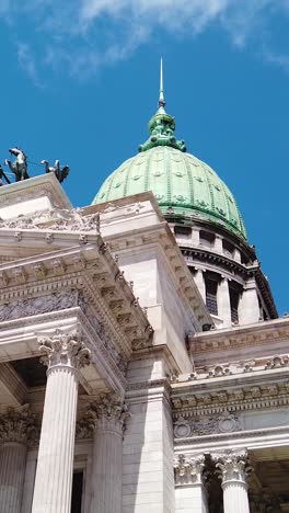 vertical of national congress of argentina with waving flag and sculptures in daylight
