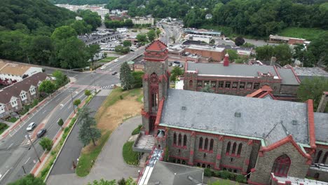 Eine-Luftaufnahme-Einer-Großen-Kirche-An-Einem-Bewölkten-Tag-In-Einem-Vorstadtviertel-Auf-Long-Island,-New-York,-Mit-Grünen-Bäumen