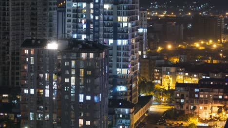 multistorey buildings with changing window lighting at night in city. timelapse