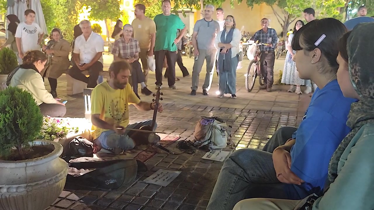 Musicista di strada che suona uno strumento tradizionale per la folla in una piazza pubblica