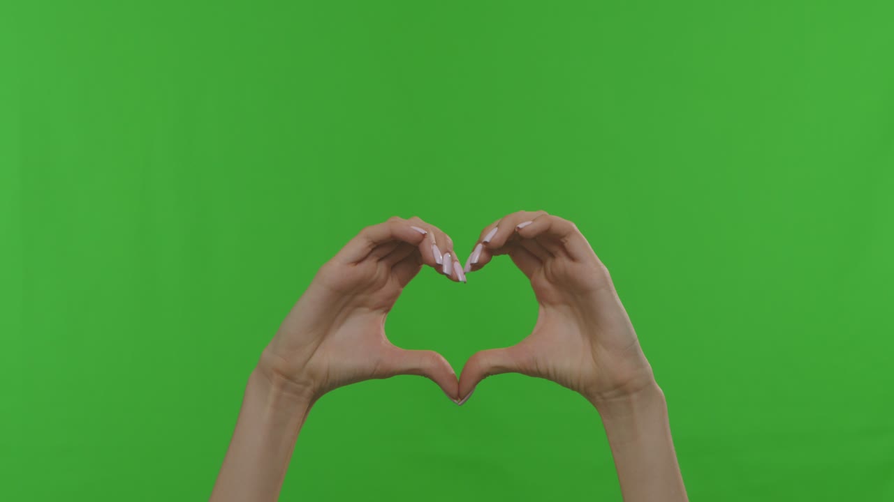 manos formando una forma de corazón en una pantalla verde