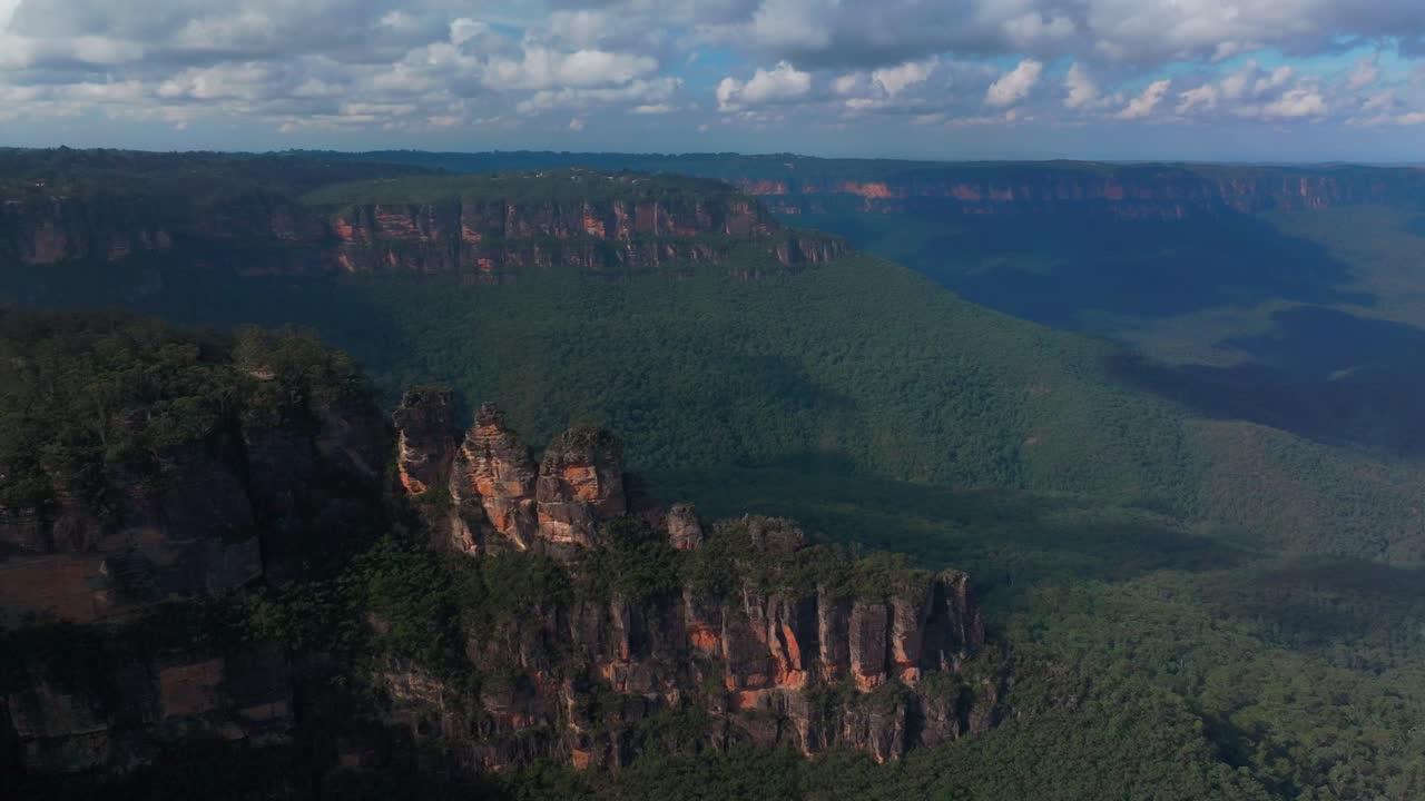punto de eco mirador tres hermanas paseo por el acantilado dron aéreo montañas azules katoomba sydney nsw australia patrimonio mundial parque nacional árbol de goma de eucalipto bosque cielo azul día soleado nubes movimiento hacia atrás