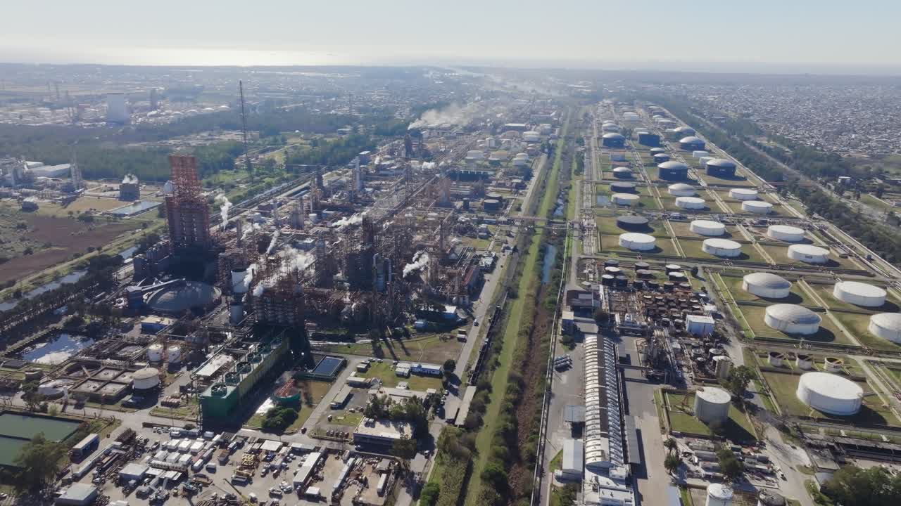 Aerial drone view of refinery storage tanks and suburbs in Argentina