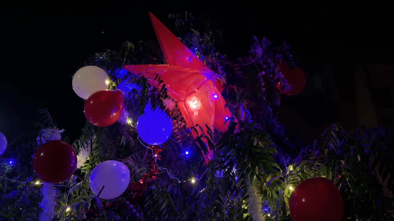 Juledekoration med lysende stjerneornament og balloner om natten til juleaftensfest.