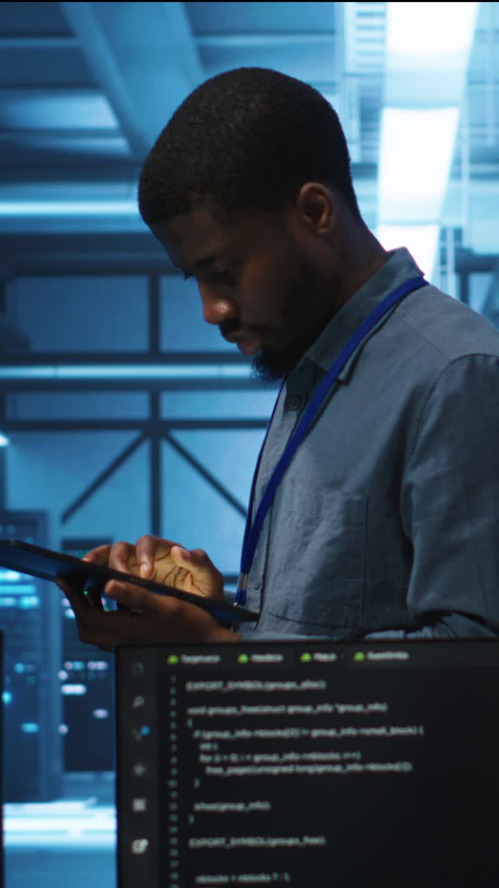 IT Engineer Using Tablet in Server Room with Code on Screens