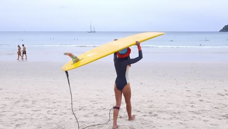 mujer con una tabla de surf en una playa