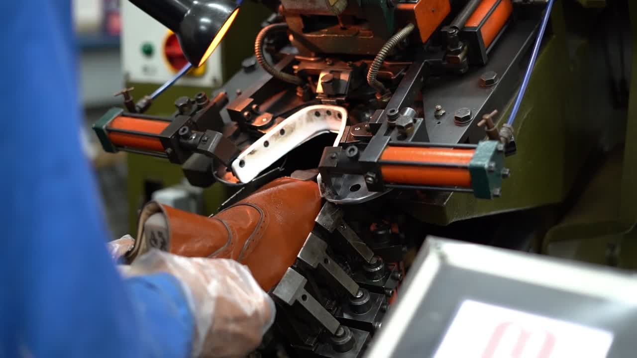 a craftsman handmade a shoe by a machine, close up shot, insert shot