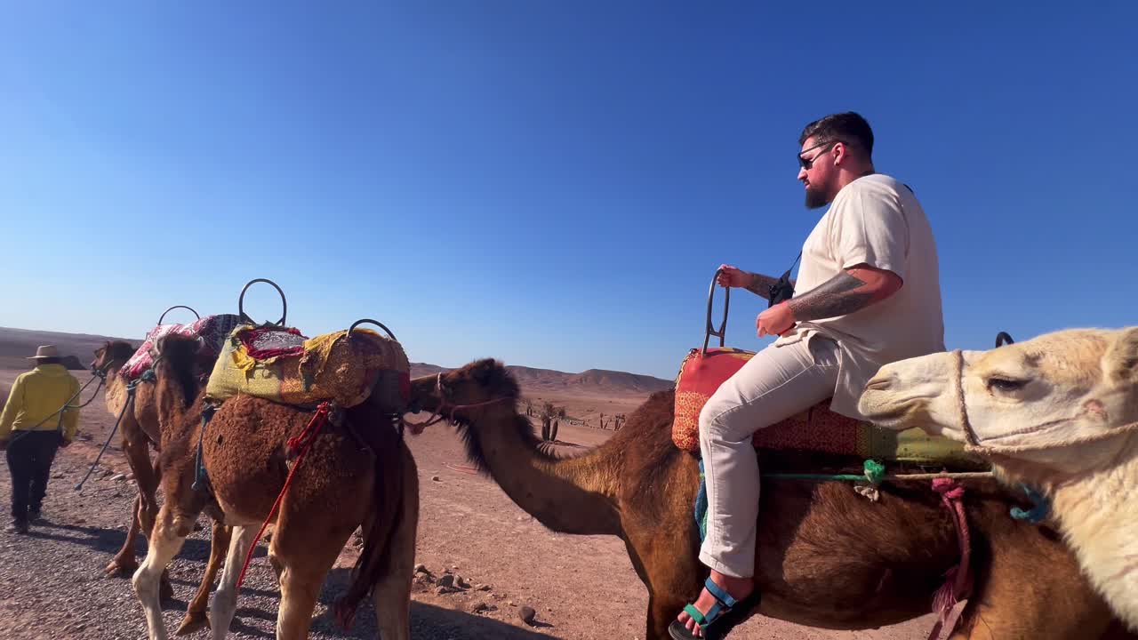 Tourist riding camel in Agafay desert Marrakech Morocco holiday excursion