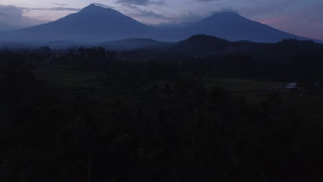 Scenic-Aerial-Perspective-of-Licin,-Banyuwangi-with-Majestic-Mountains-in-the-Background