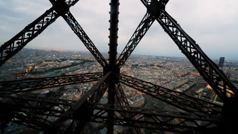 shot from inside an elevator going up the tour eiffel, with the city of paris in the background, france