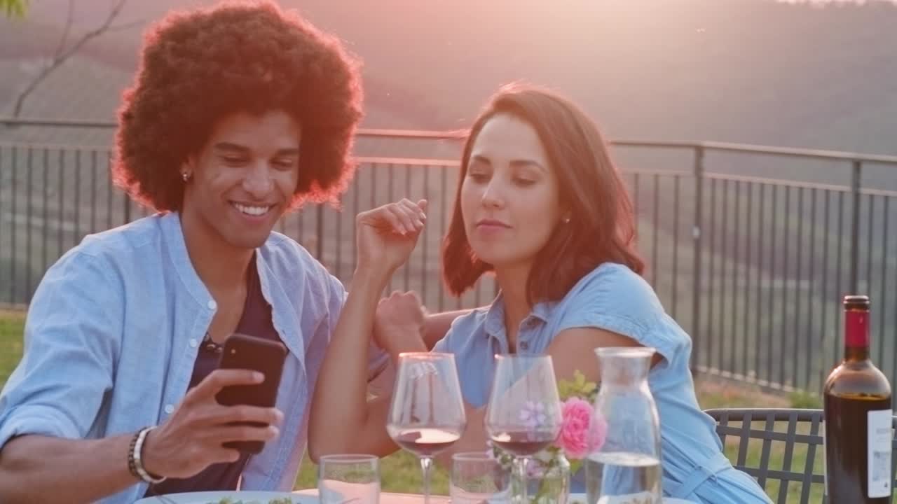 hombre y mujer usando un teléfono inteligente tomando una selfie durante una cena romántica al aire libre al atardecer. amigos viaje italiano en umbria.4k cámara lenta