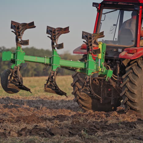 farmer in tractor customize equipment for cultivating the soil. close-up view of agricultural tractor in the field at daytime. seasonal works in rural place.