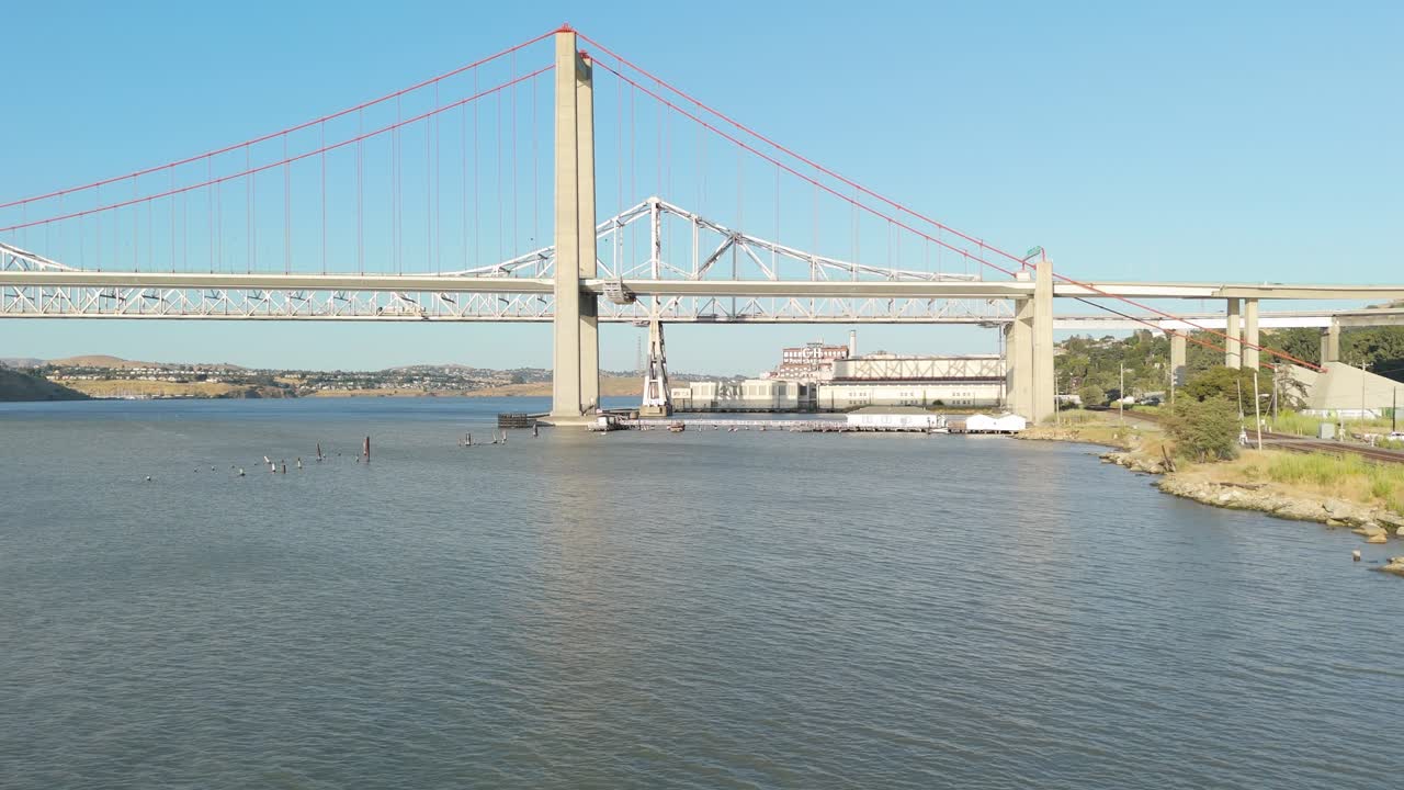 The Alfred Zampa Memorial Bridge dominates the horizon as the drone sweeps past coastal terrain and industrial charm of Crockett, California