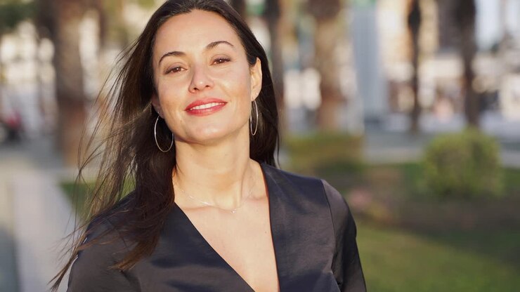 mujer sonriente en vestido negro al aire libre