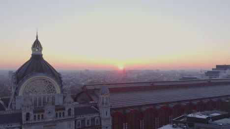 video shows the beautiful train station in antwerp with sunrise background. the sky orange sky turn the station into golden color. the station is the most beautiful station in world.