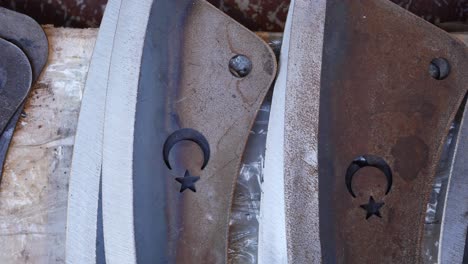 primer plano de cuchillas metálicas con diseños de luna creciente y estrella