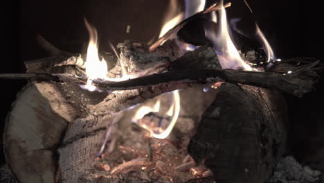 4K-Nahaufnahme-Eines-Warmen-Holzfeuers,-Das-In-Einer-Kalten-Nacht-In-Einem-Traditionellen-Ländlichen-Schwarzen-Kamin-In-Einem-Winterhaus-Brennt