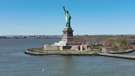 aerial drone shot showing many tourist visiting statue of liberty during beautiful summer day in nyc