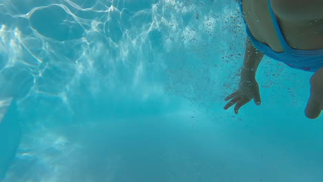 siblings touch hands underwater