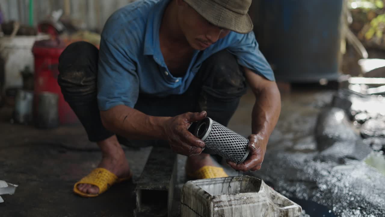 Man Changing Oil Filter in a Garage