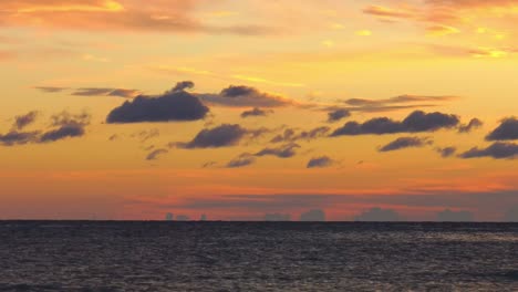 time lapse cloudscape over ocean with orange sky at dawn, zoom out