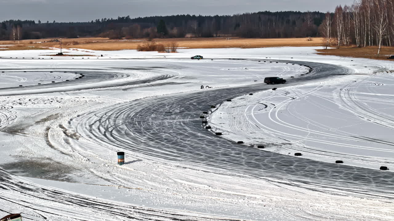 Cars drifting on snowy tracks showing skill and control in winter