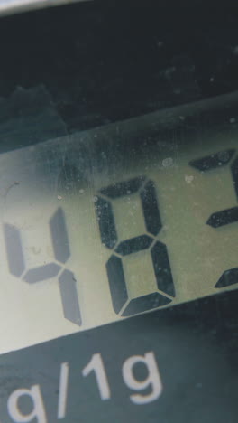 changing numbers on digital kitchen scales screen and start button shows zero at bright light extreme close view