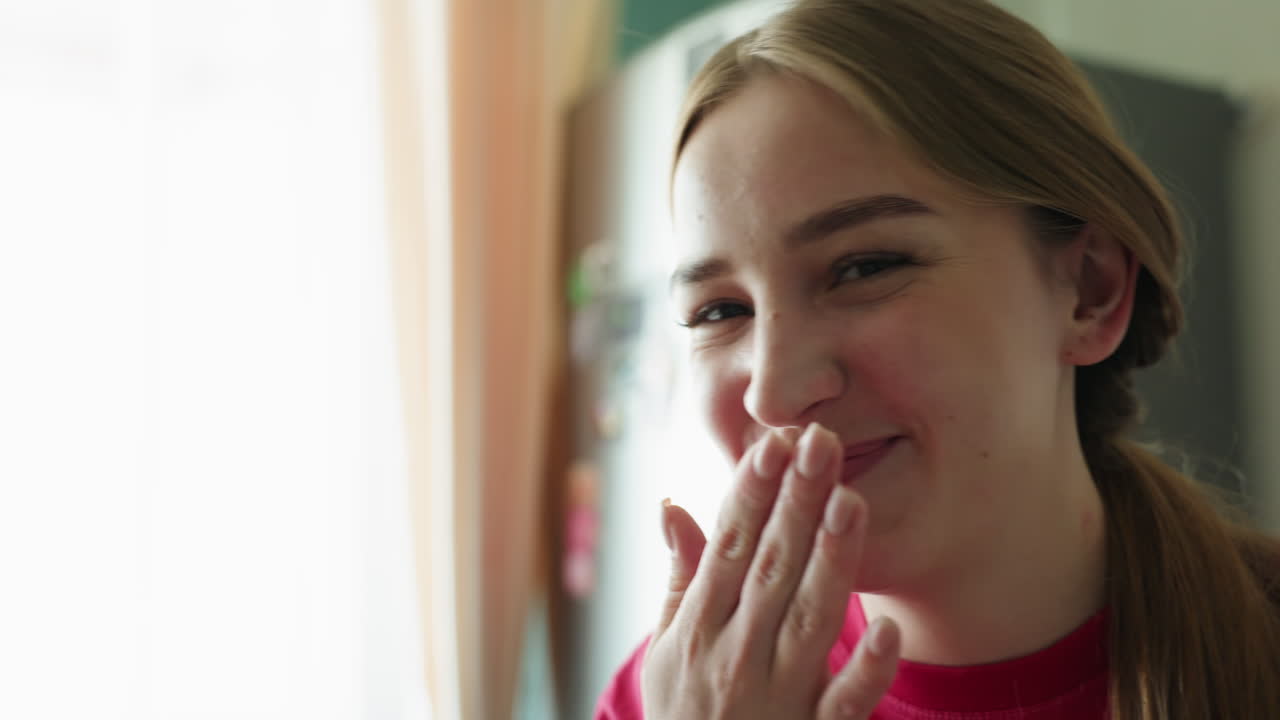 Mujer alegre sonriendo, joven rubia que expresa felicidad cerca de electrodomésticos de cocina, mujer juguetona con coleta rubia capturando una risa espontánea y gestos cariñosos