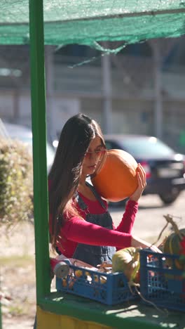 woman buying pumpkins at a farmer's market