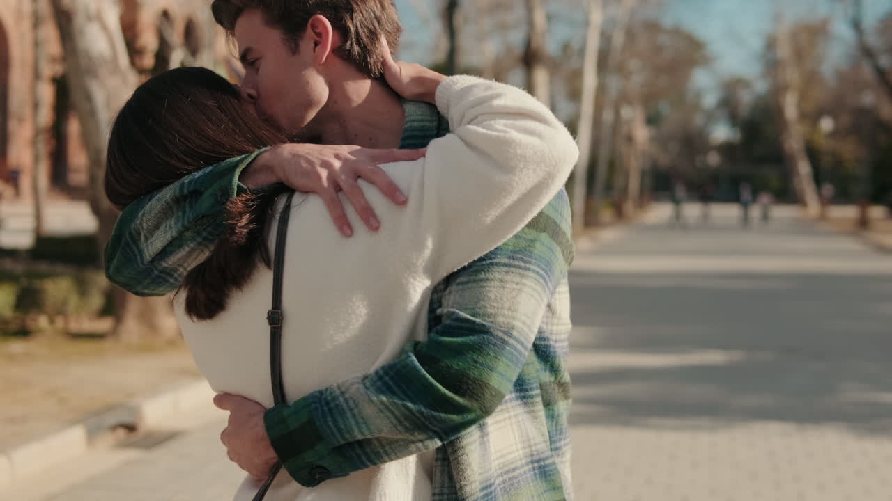 Young loving couple meet on the street, hug and kiss