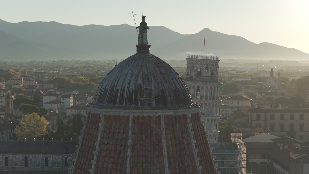Cinematic sunrise drone footage of the Leaning Tower of Pisa and the Piazza dei Miracoli, captured with smooth aerial movements and soft early morning light