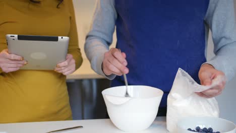 mid-section of man mixing dough in bowl