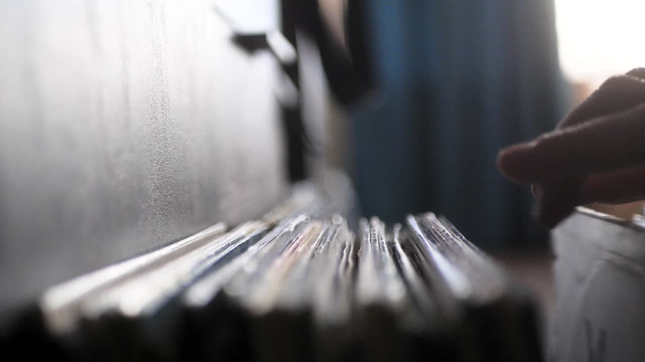 Male hands going through vinyl records, close up view