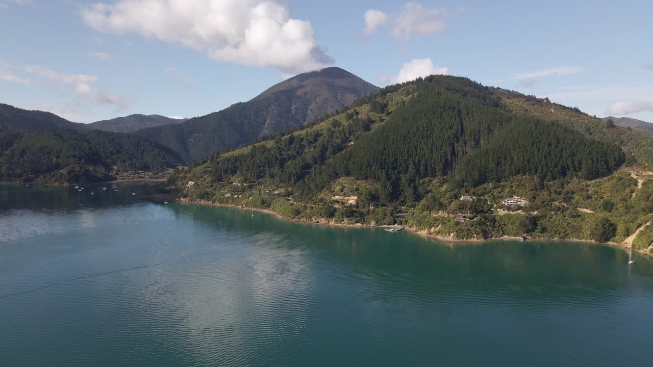 뉴질랜드 말보로에 있는 풍부한 해안 산의 봉우리에 닿는 큰 적운 구름